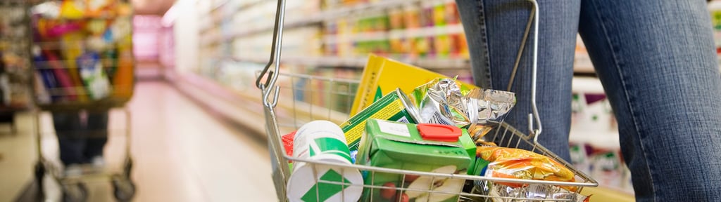 Close-up of a shopping basket in a supermarket aisle