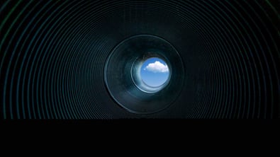 Looking at the sky with clouds through a pipe