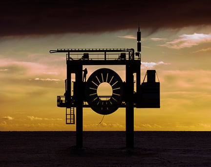 Tidal turbine in silhouette at sunset