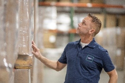 Profissional da LRQA inspecionando mercadorias armazenadas em centro logístico